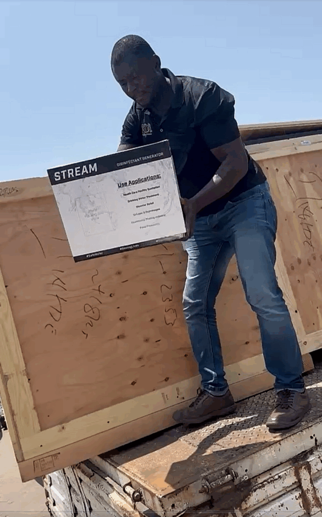 Man unloading a STREAM disinfectant generator from a crate